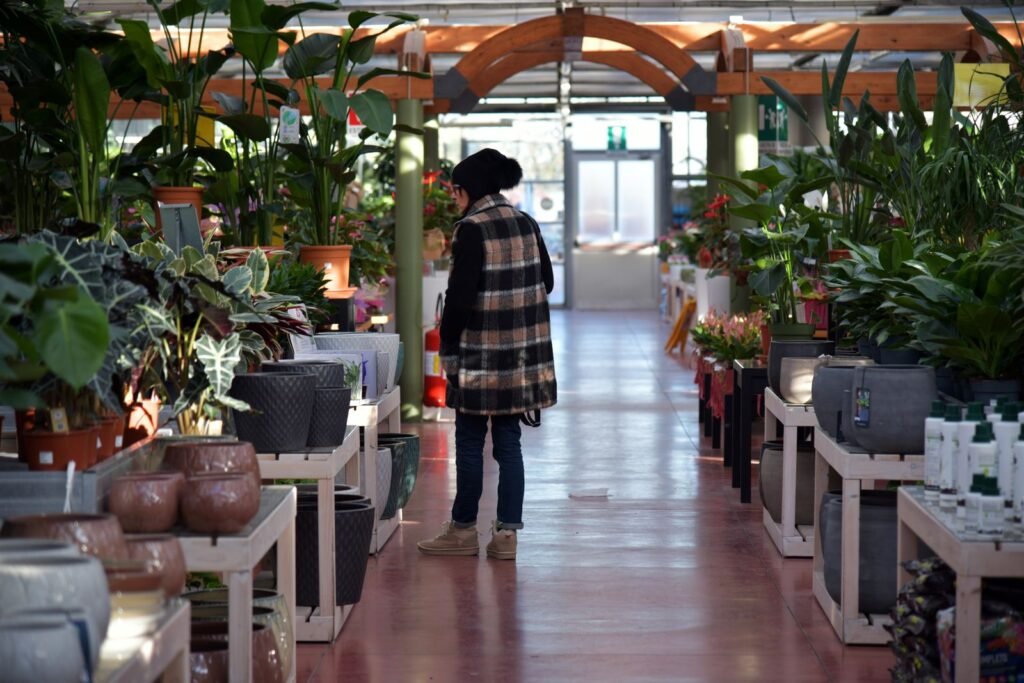 A shopper browsing plants in a bright garden centre